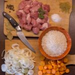 砧板上放了肉、洋蔥、紅蘿蔔及米