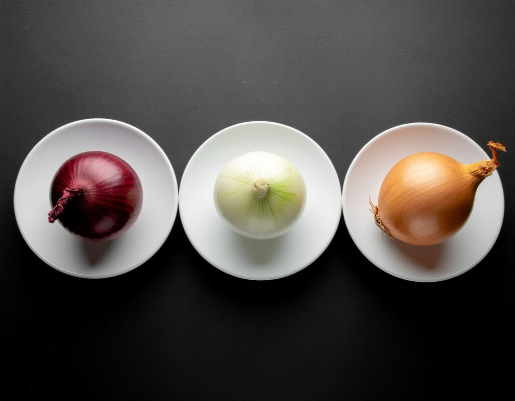 三盤料理並列擺放，分別使用白洋蔥、黃洋蔥、紫洋蔥入菜，從口感到色澤各具特色，凸顯洋蔥種類對味道的影響。