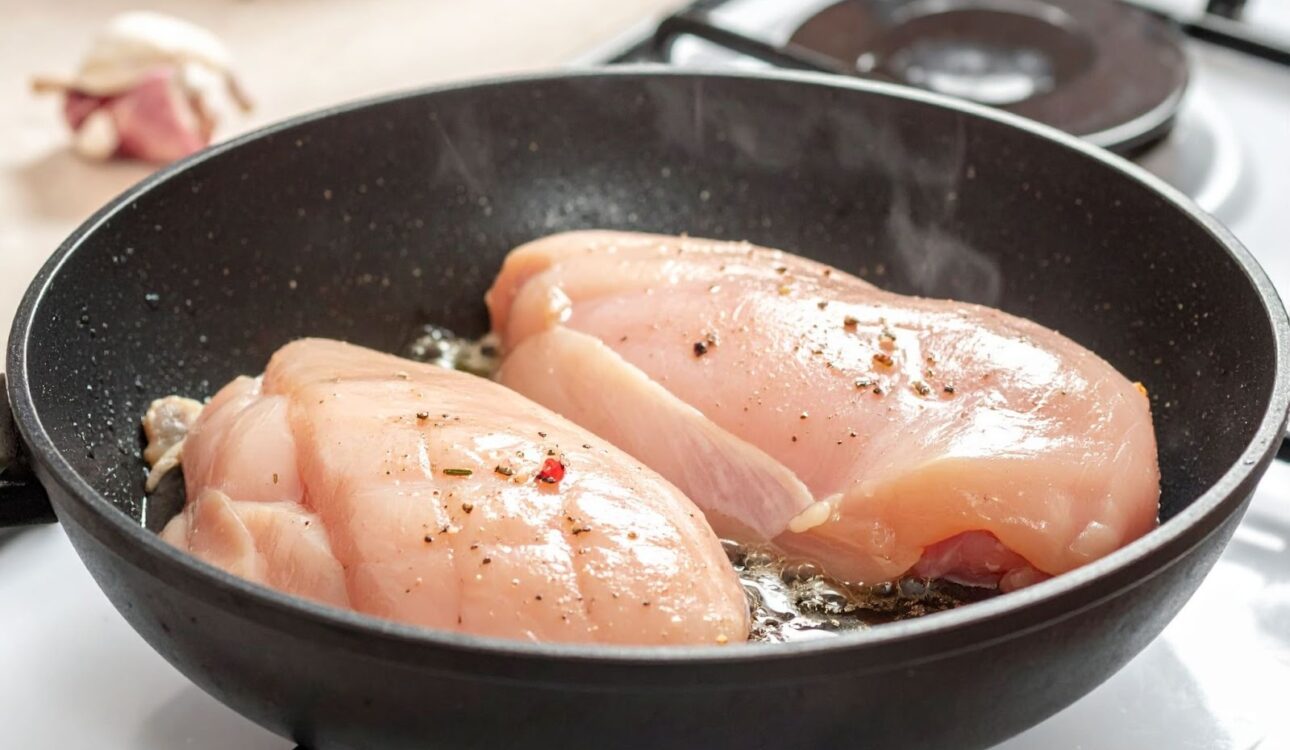 平底鍋中的雞胸肉煎到表面乾白