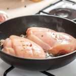 平底鍋中的雞胸肉煎到表面乾白